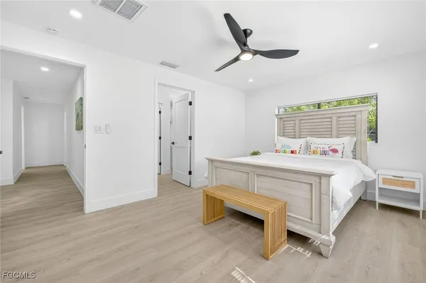 a spacious bedroom with a bed and a chandelier