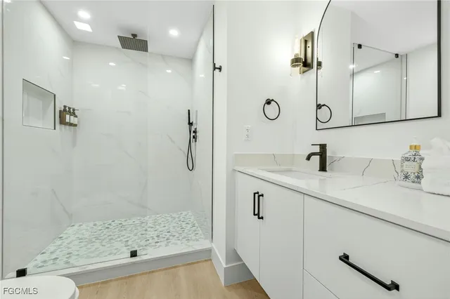 a bathroom with a shower sink and mirror