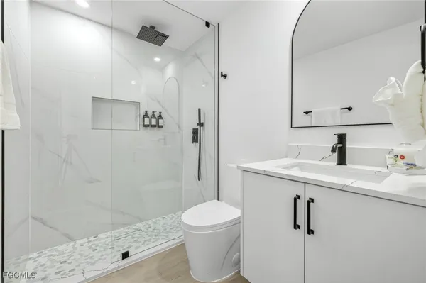 a bathroom with a sink a toilet and shower
