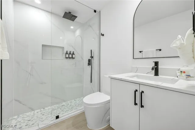 a bathroom with a sink a toilet and shower