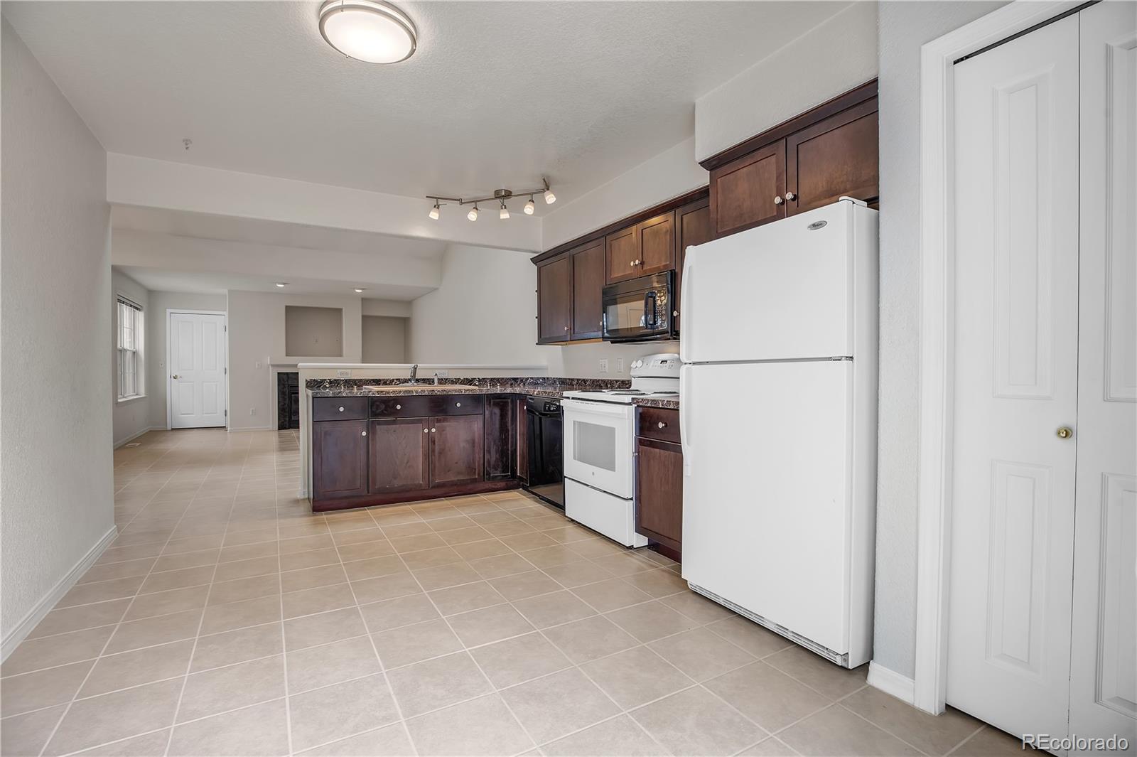 11690 West 46th Avenue Wheat Ridge, CO 80033 - Photo 11 of 33 a large kitchen with cabinets and stainless steel appliances