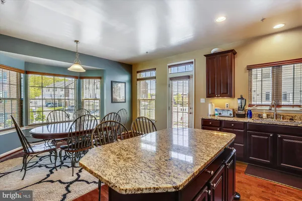 a kitchen with granite countertop a refrigerator and a stove top oven