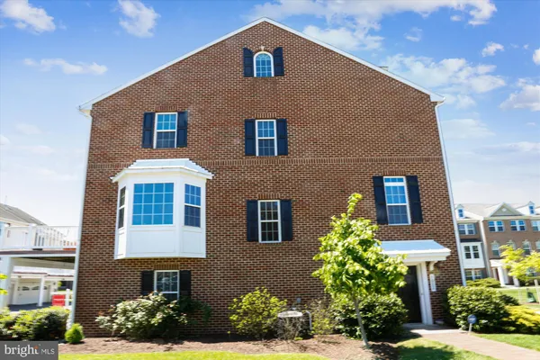 a kitchen with kitchen island granite countertop wooden cabinets a refrigerator and wooden floors