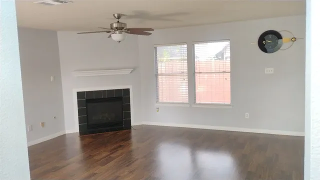 an empty room with windows and a fireplace