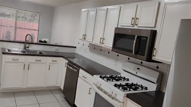 a kitchen with granite countertop a sink stove and cabinets