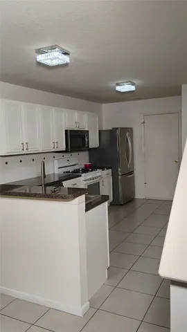 a kitchen with stainless steel appliances granite countertop a refrigerator and a stove top oven