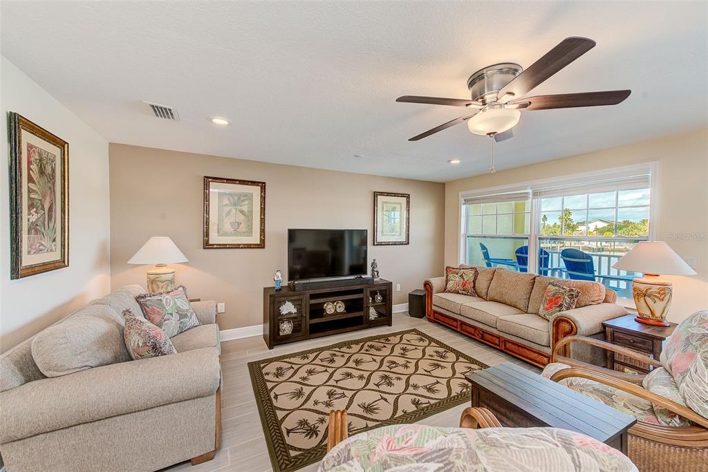 100 Windrush Boulevard, Unit 2 Indian Rocks Beach, FL 33785 - Photo 16 of 73 a living room with furniture a flat screen tv and a window