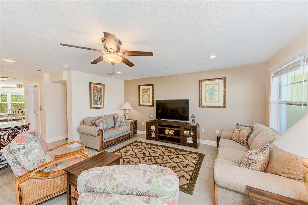 100 Windrush Boulevard, Unit 2 Indian Rocks Beach, FL 33785 - Photo 19 of 73 a living room with furniture a flat screen tv and a window
