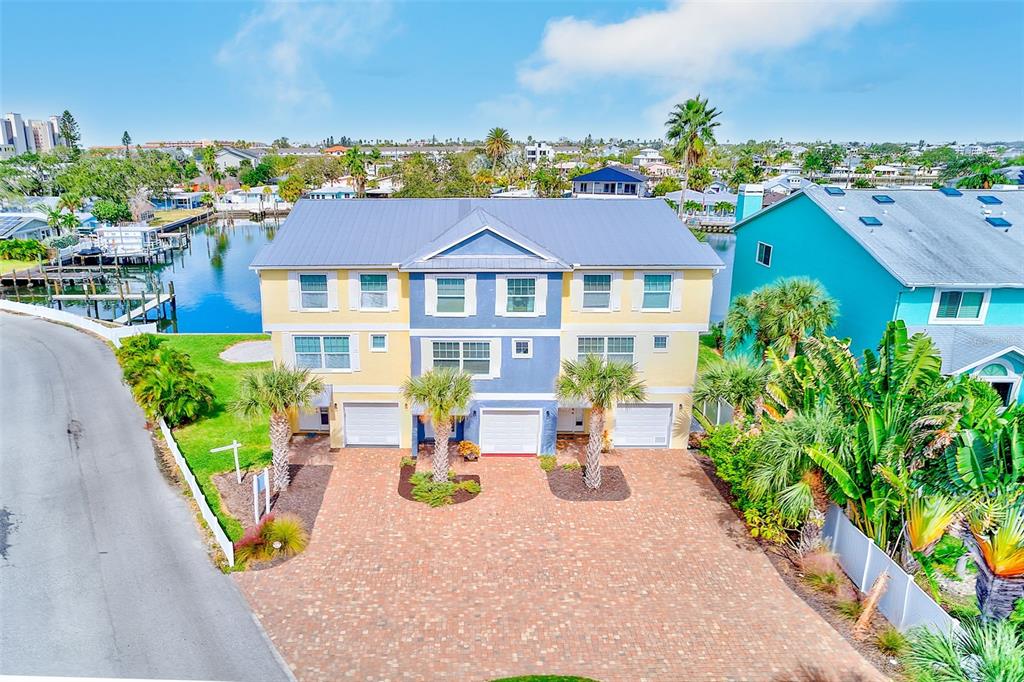 100 Windrush Boulevard, Unit 2 Indian Rocks Beach, FL 33785 - Photo 2 of 73 an aerial view of a house with swimming pool and glass top table and chairs