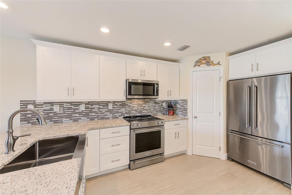 100 Windrush Boulevard, Unit 2 Indian Rocks Beach, FL 33785 - Photo 21 of 73 a kitchen with a stove microwave and refrigerator