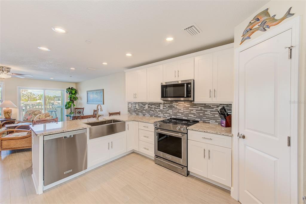 100 Windrush Boulevard, Unit 2 Indian Rocks Beach, FL 33785 - Photo 24 of 73 a kitchen with white cabinets and white appliances