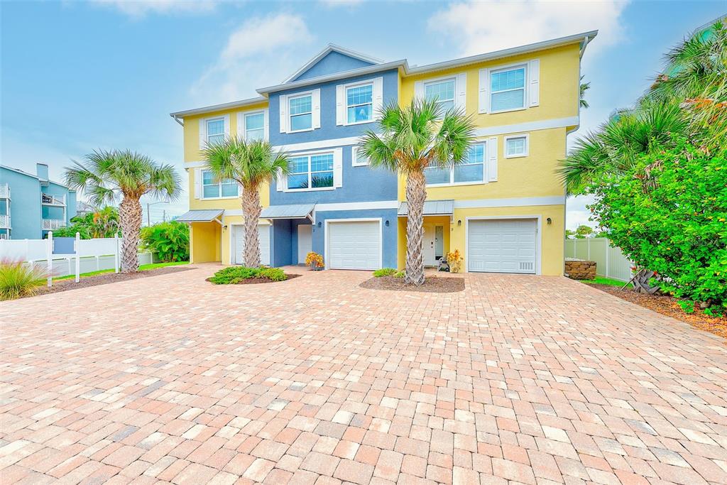 100 Windrush Boulevard, Unit 2 Indian Rocks Beach, FL 33785 - Photo 3 of 73 a front view of a house with a yard and a garage