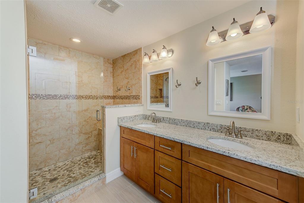100 Windrush Boulevard, Unit 2 Indian Rocks Beach, FL 33785 - Photo 34 of 73 a bathroom with a granite countertop sink mirror and double