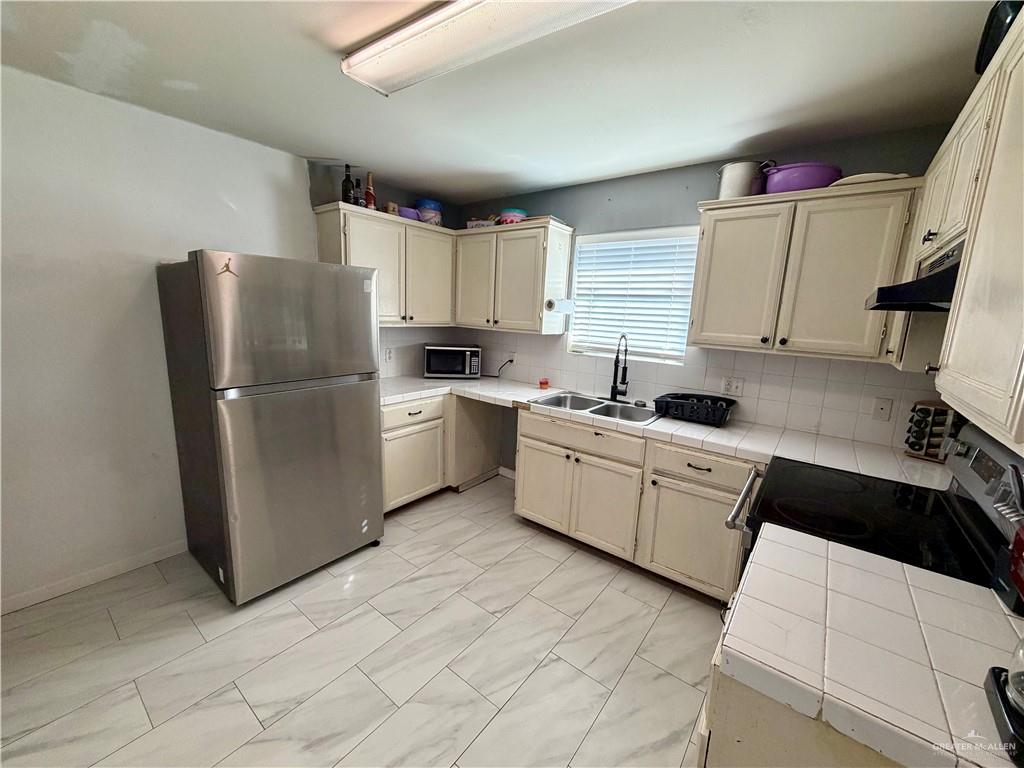 434 Serg Loop Alamo, TX 78516 - Photo 4 of 17 a kitchen with cabinets a sink and white appliances
