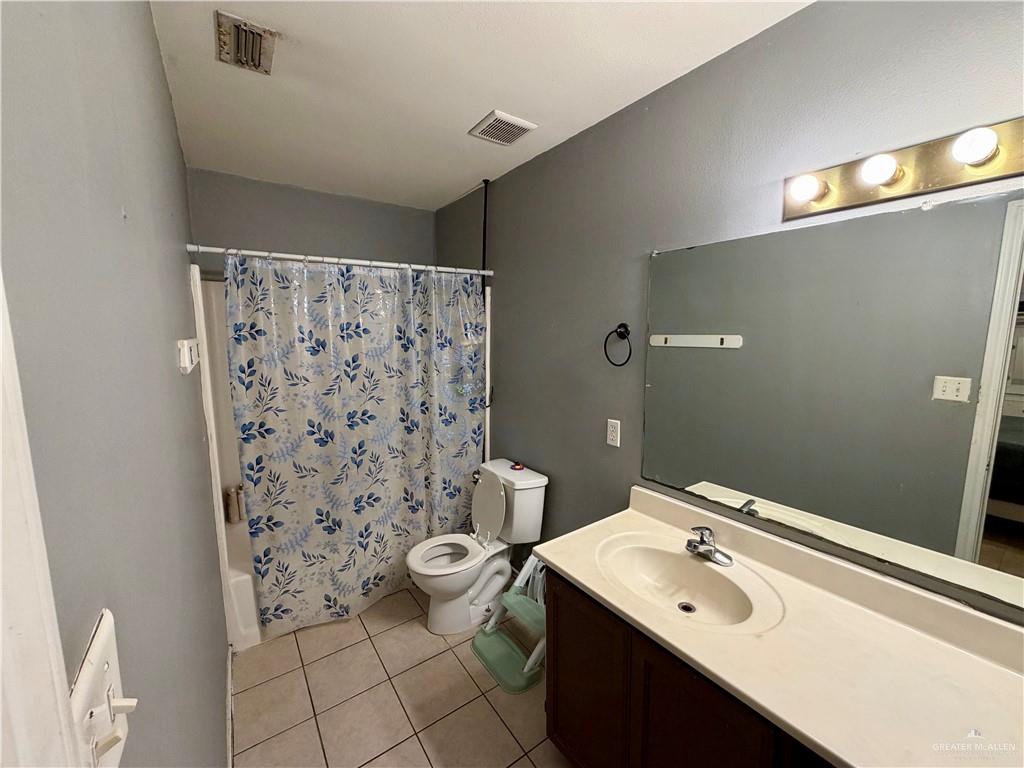 434 Serg Loop Alamo, TX 78516 - Photo 8 of 17 a bathroom with a sink a toilet and shower curtain