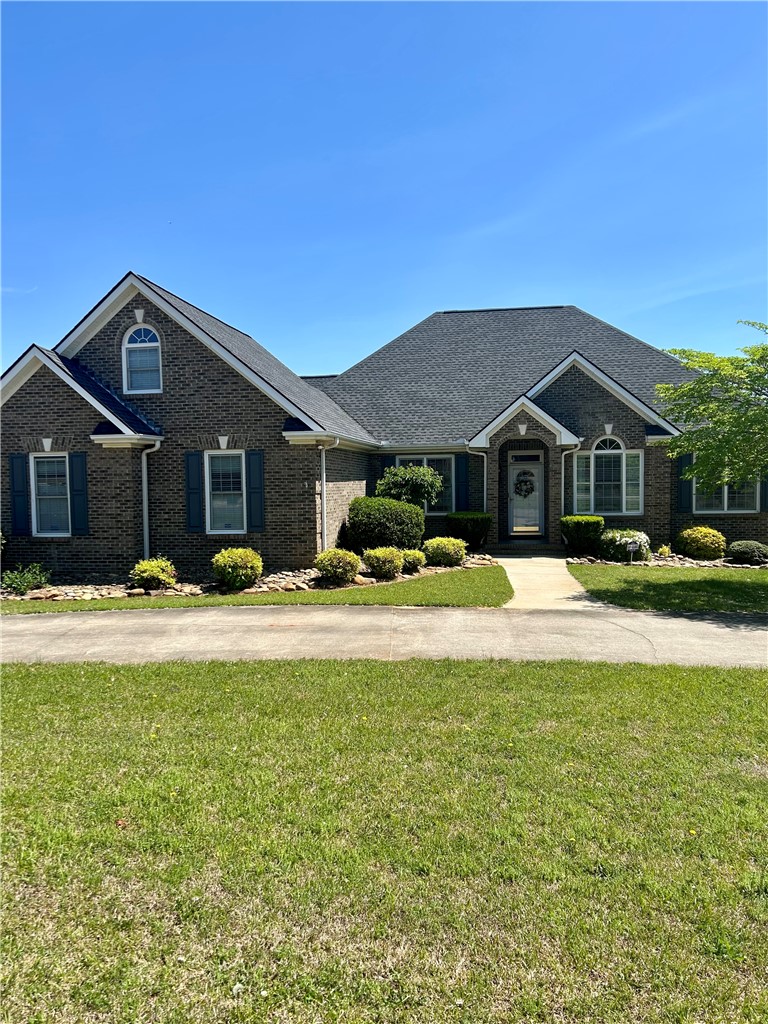 This classic brick residence features a welcoming entrance and well-maintained landscaping.