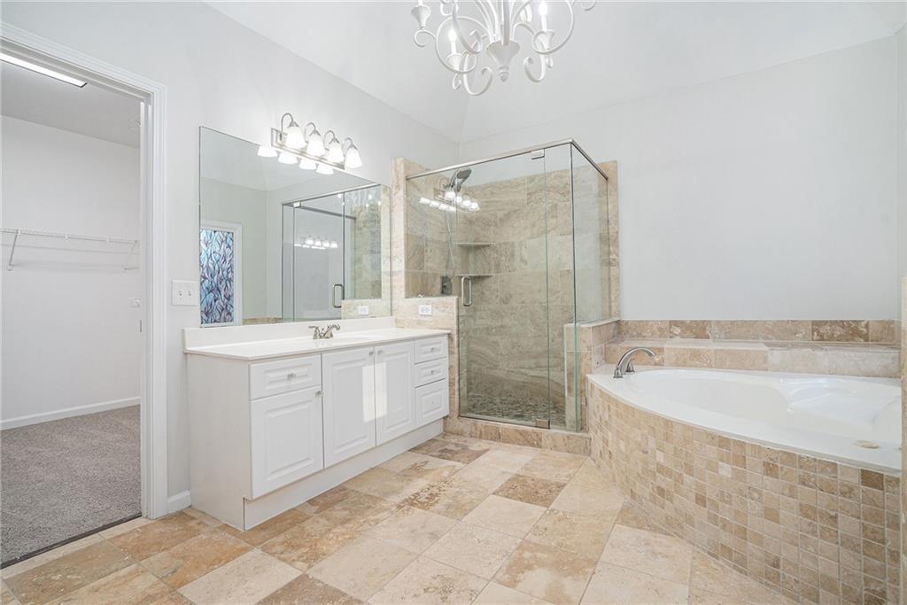 523 Sycamore Point Woodstock, GA 30189 - Photo 17 of 34 a spacious bathroom with a bathtub shower sink mirror and a bathtub