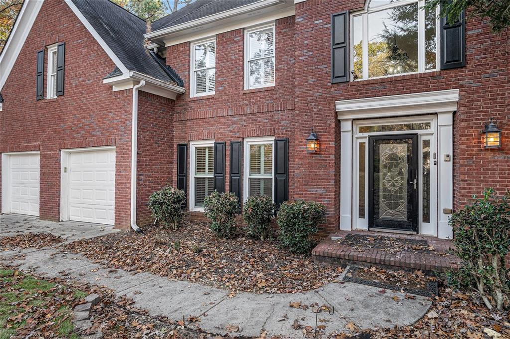 523 Sycamore Point Woodstock, GA 30189 - Photo 3 of 34 a view of a brick house with plants and large tree