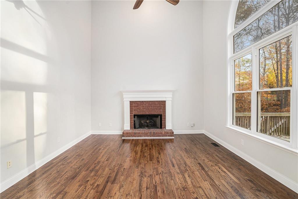 523 Sycamore Point Woodstock, GA 30189 - Photo 7 of 34 a view of an empty room with wooden floor fire place and windows