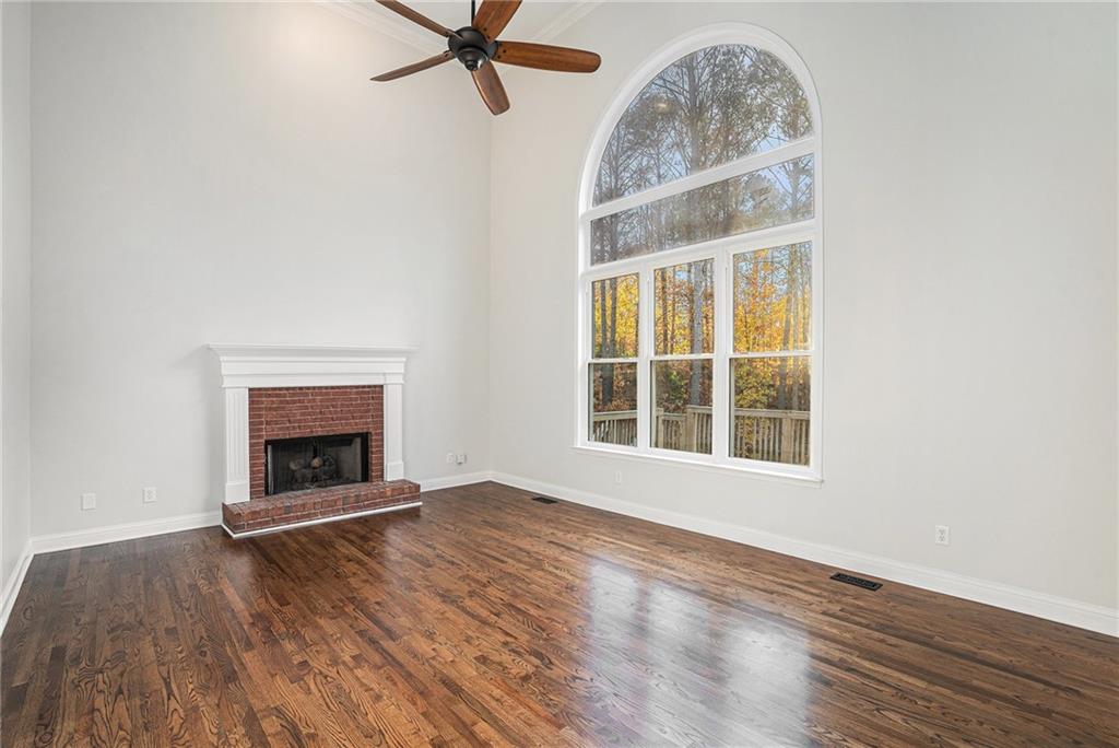 523 Sycamore Point Woodstock, GA 30189 - Photo 8 of 34 an empty room with a fireplace and wooden floor