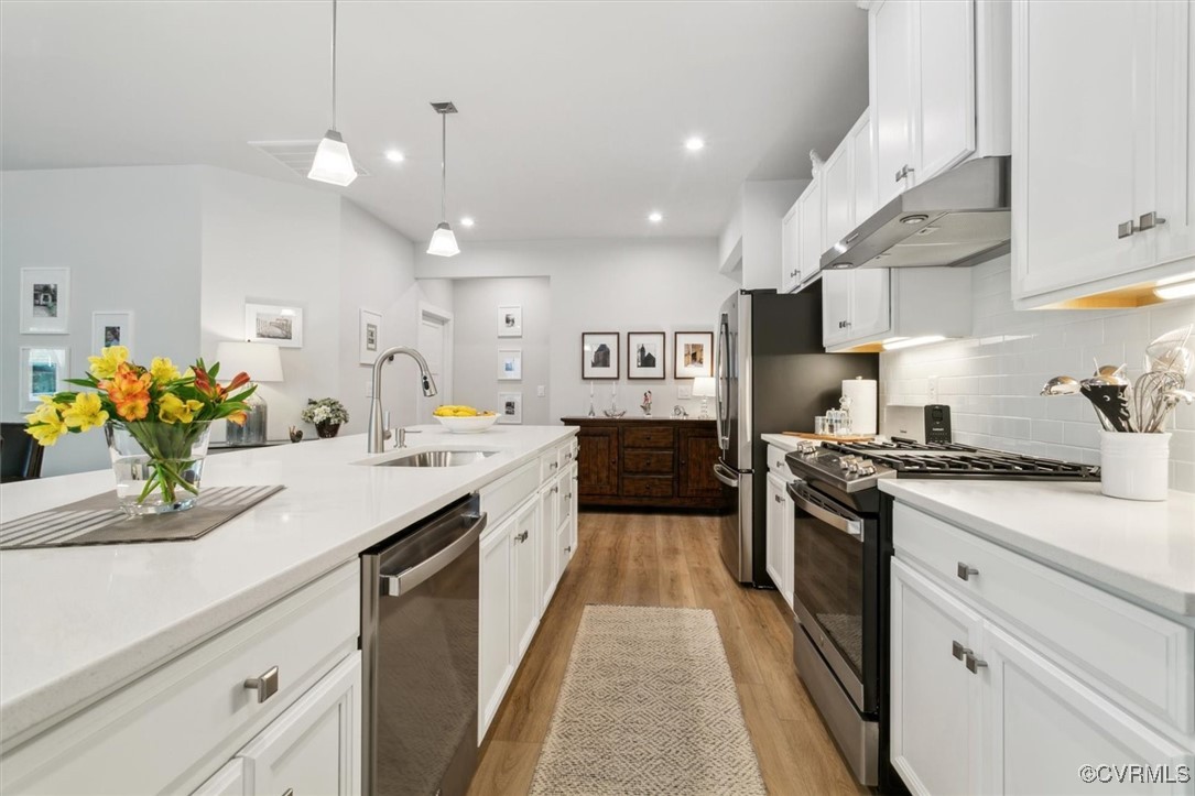 115 Apprentice Landing Williamsburg, VA 23185 - Photo 18 of 49 a large kitchen with stainless steel appliances kitchen island granite countertop a sink dishwasher a stove and a dining table with wooden floor