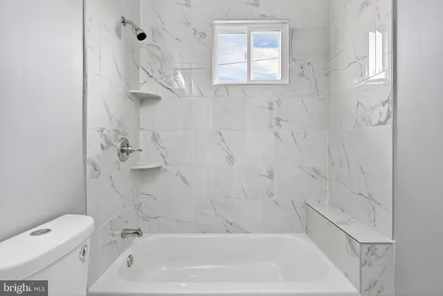 a bath room with a toilet and a bath tub