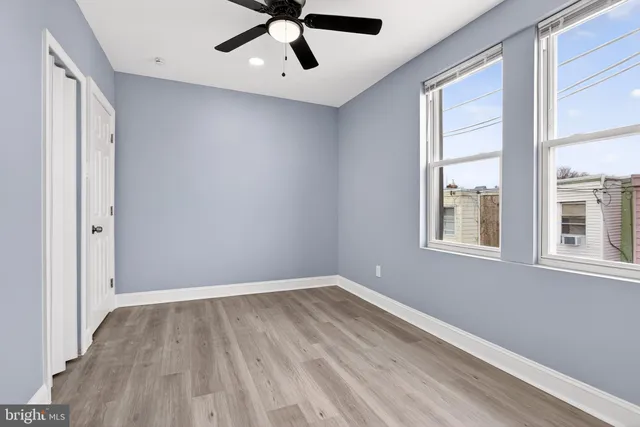 a view of a big room with wooden floor and windows