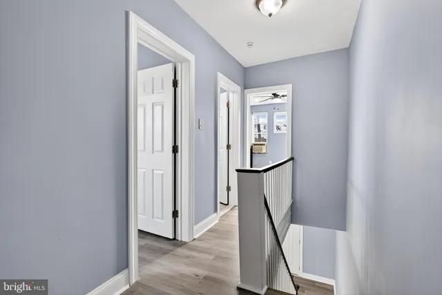 a view of a hallway with wooden floor and entryway