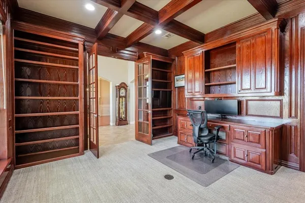 a spacious bedroom with a bed a table and a chandelier