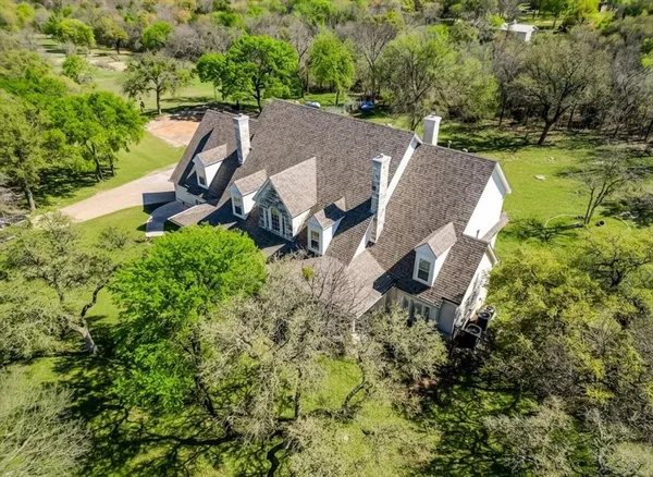 an aerial view of a house with outdoor space and a lake view in back
