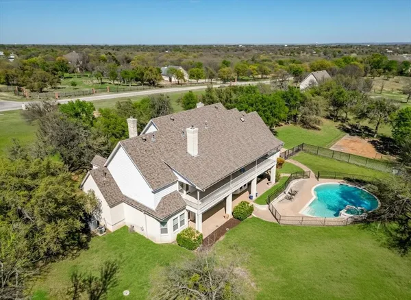 an aerial view of a house with a yard and lake view