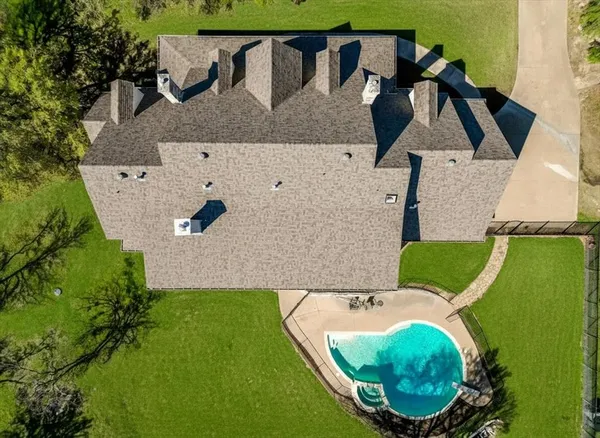 an aerial view of a house with swimming pool and outdoor space
