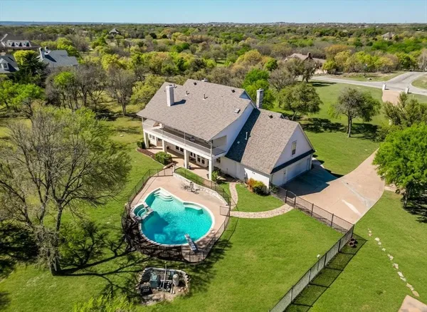 an aerial view of a house with backyard space and lake view