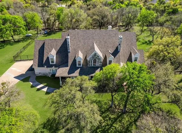 an aerial view of a house with a garden and trees