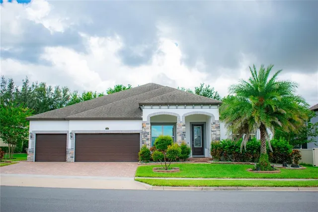 a front view of a house with a garden and palm trees