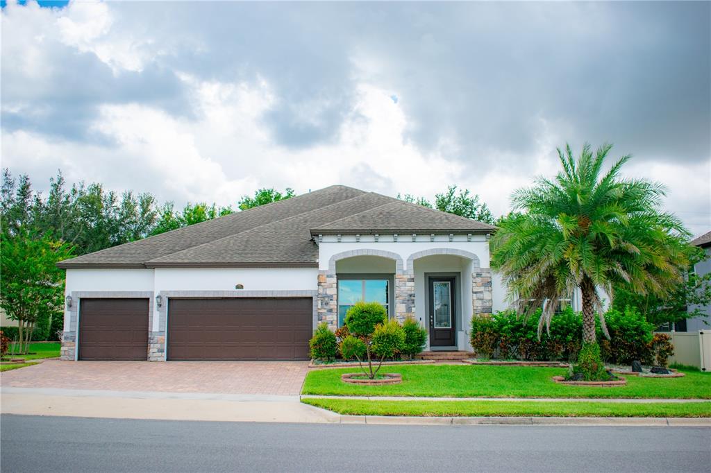 a front view of a house with a garden and palm trees