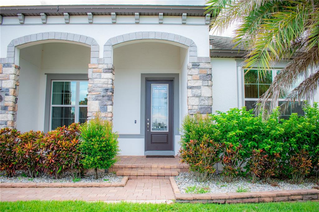 17993 Gourd Neck Loop Winter Garden, FL 34787 - Photo 3 of 29 a view of a brick house with plants and large tree
