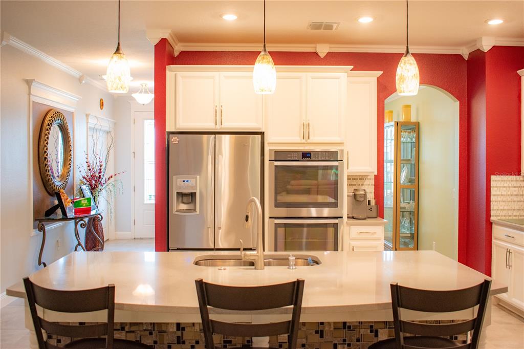 17993 Gourd Neck Loop Winter Garden, FL 34787 - Photo 4 of 29 a kitchen with stainless steel appliances a dining table chairs and couches with wooden floor