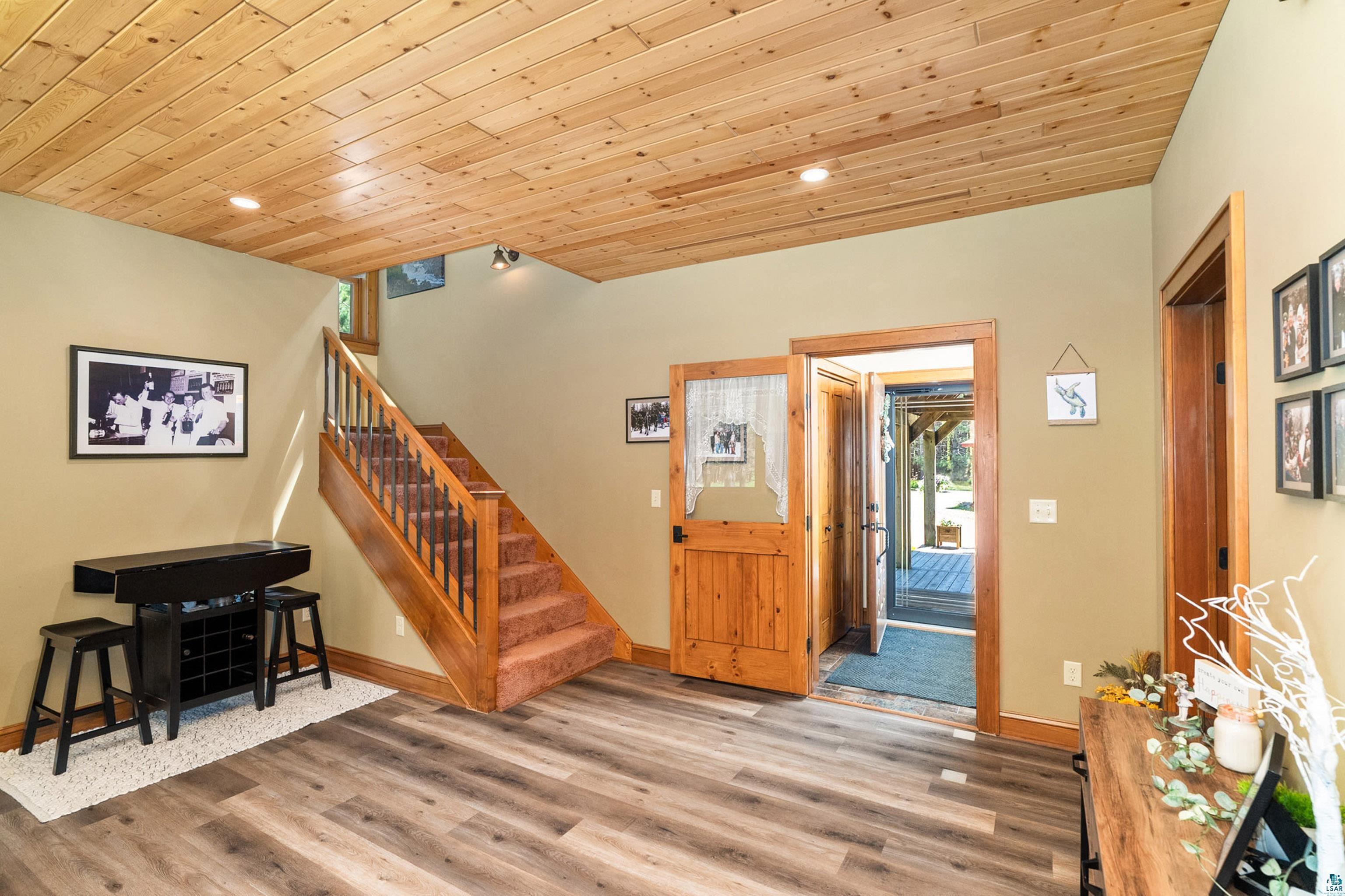75 East Stark Road Esko, MN 55733 - Photo 24 of 87 Wood-finish flooring and a natural wood plank ceiling define this space, featuring a wood-railed staircase with carpeted treads