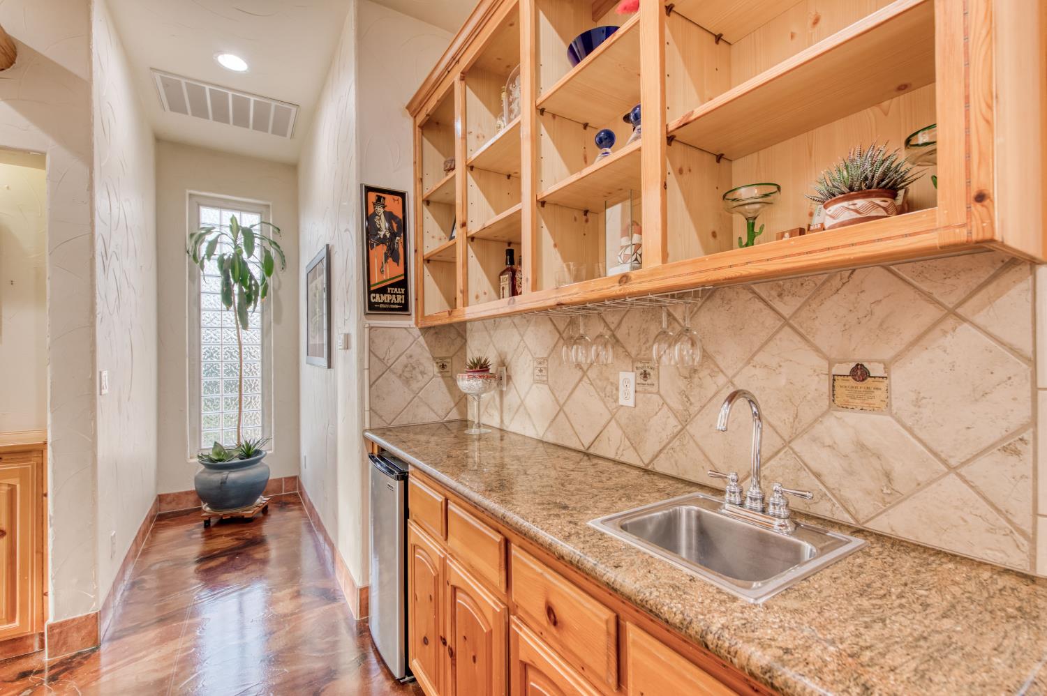 17433 El Dorado Madera, CA 93636 - Photo 14 of 49 a kitchen with granite countertop a sink and a wooden floor