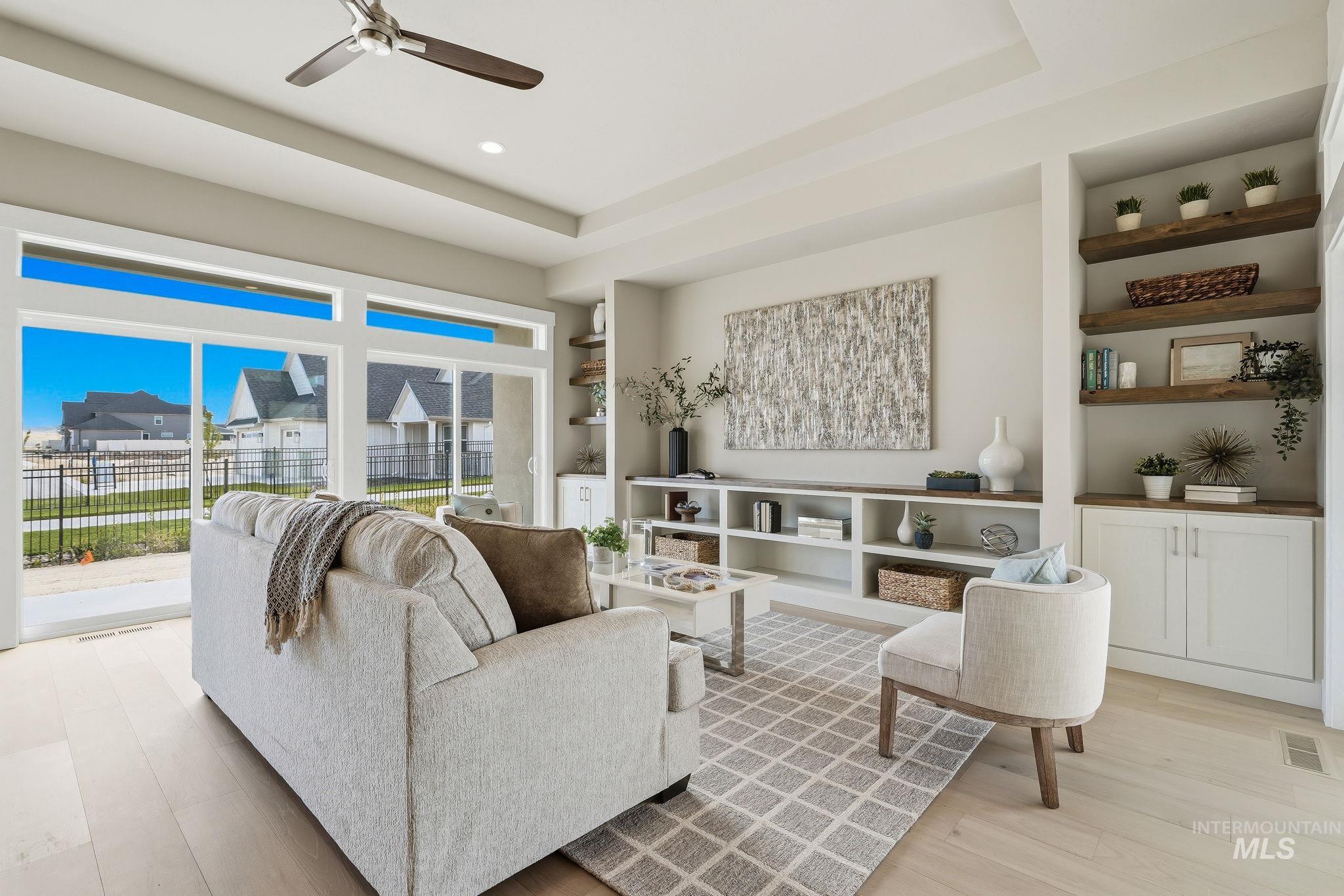 470 South Radiator Way Boise, ID 83716 - Photo 5 of 50 Spacious living area featuring light wood-finish flooring, a ceiling fan with integrated lighting, and a large sliding glass door with transom windows