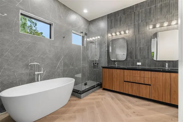 a bathroom with a large tub sink and mirror