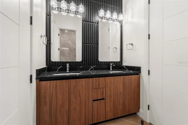 a bathroom with double vanity and a mirror