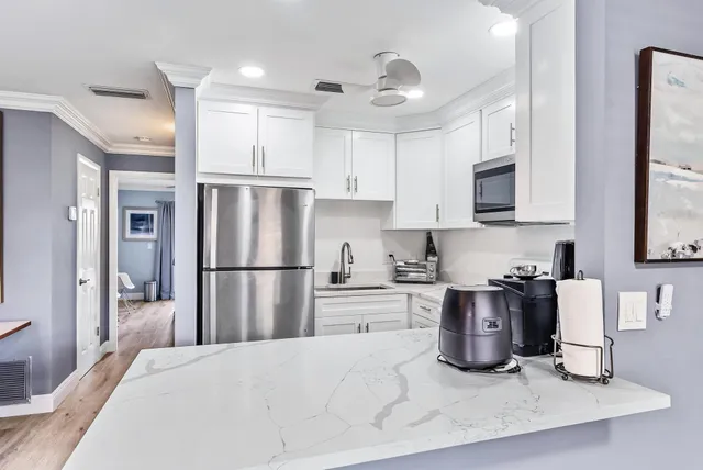 a kitchen with stainless steel appliances granite countertop a refrigerator sink and stove