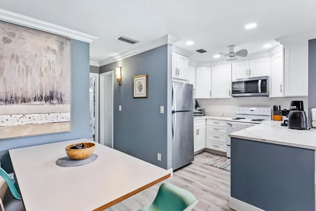 a kitchen with stainless steel appliances a refrigerator sink and wooden floor