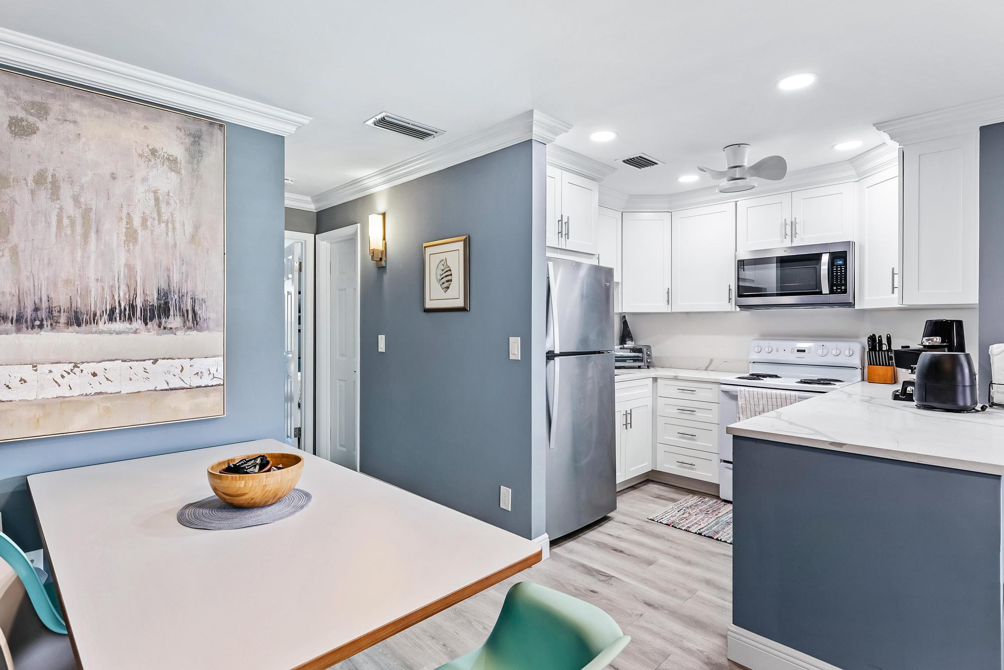 2600 Southeast Ocean Boulevard, Unit A11 Stuart, FL 34996 - Photo 4 of 12 a kitchen with stainless steel appliances a refrigerator sink and wooden floor