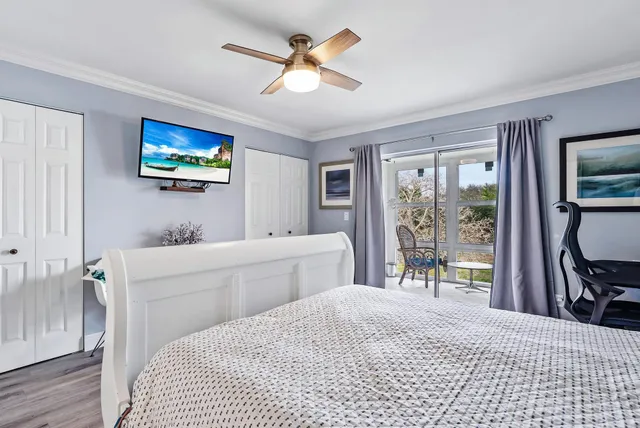 a bedroom with a bed and a flat tv screen on dresser