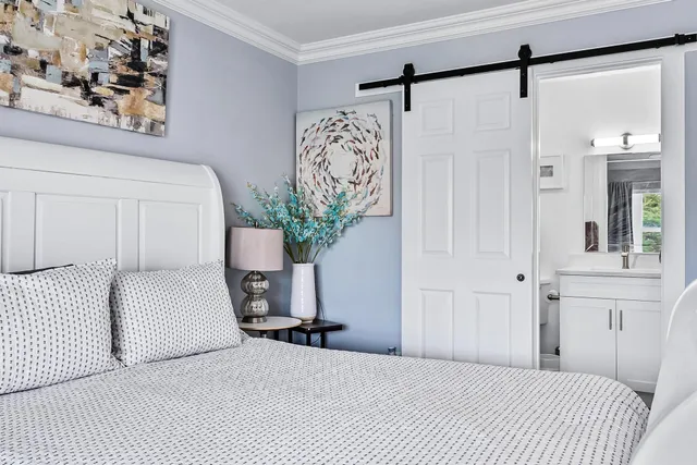 a bedroom with a large bed and a chandelier