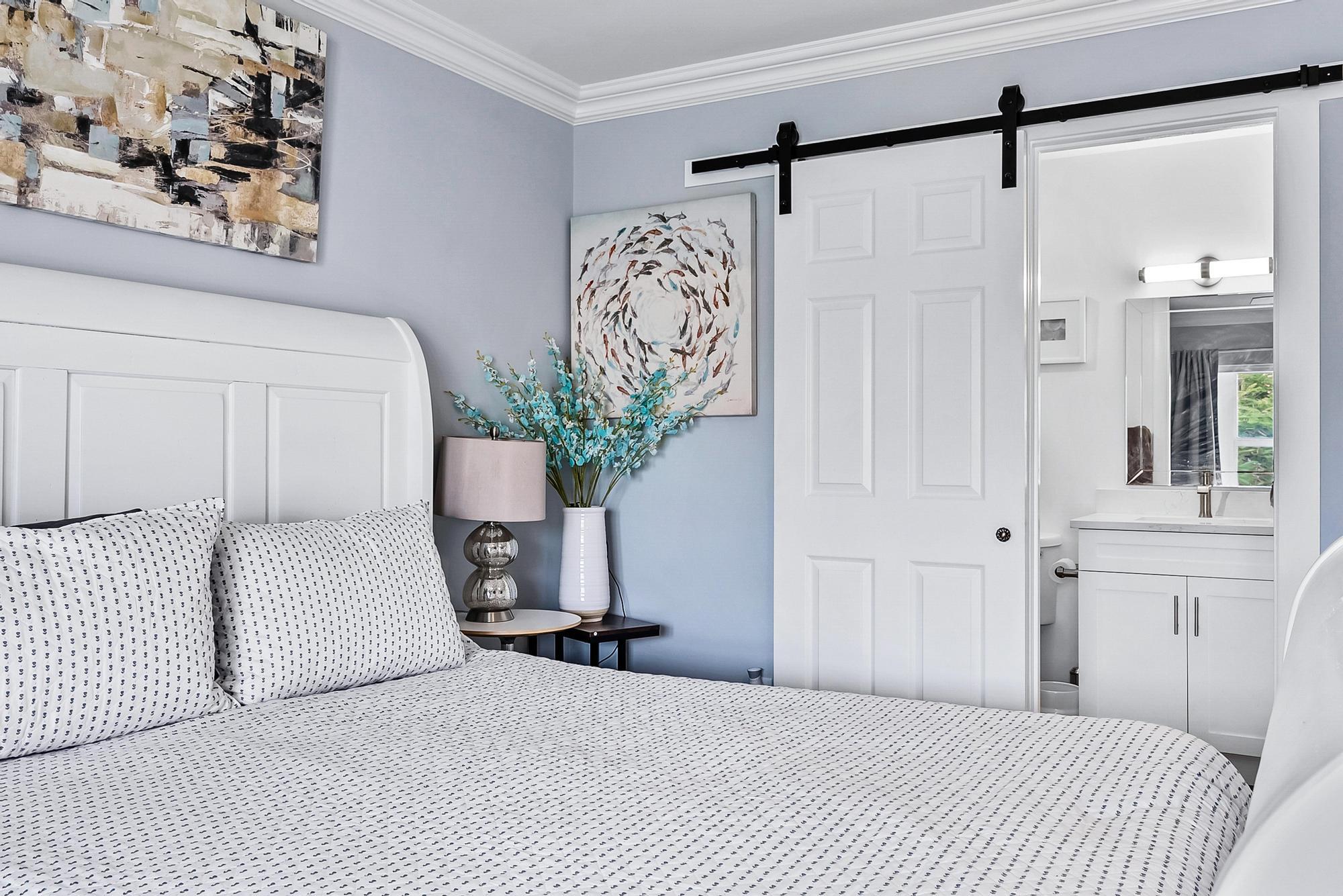 2600 Southeast Ocean Boulevard, Unit A11 Stuart, FL 34996 - Photo 9 of 12 a bedroom with a large bed and a chandelier