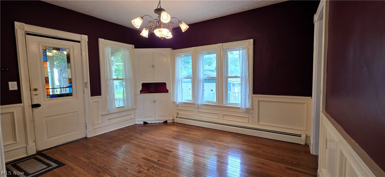 7414 Greenwich Road Seville, OH 44273 - Photo 8 of 50 Formal dining room showcasing hardwood floors, classic wainscoting, built-in cabinet, and original character.